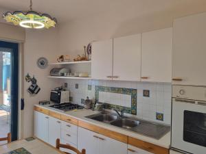 a kitchen with white cabinets and a sink at Casa Alessia Taormina in Taormina +8 photos