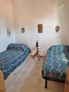 a bedroom with two beds and a table at Casa Alessia Taormina in Taormina