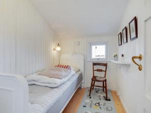 a small room with a bed and a chair at Holiday Home Githe - from the sea by Interhome in Hals