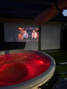 a bath tub filled with red water with two men in the background at Domek Marzenie in Radawa