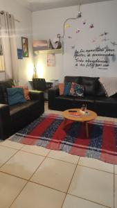a living room with couches and a table on a rug at Casa Viva Bonito in Bonito