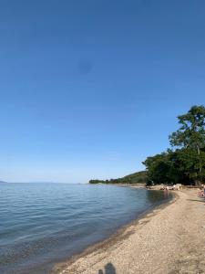 a beach with people sitting on the shore at Meraki Seaside Apartment in Stavros