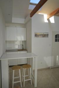 a kitchen with a white counter and two stools at Ferienappartement Teresa in Sławoszynko