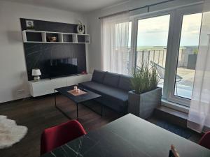 a living room with a couch and a large window at Sun Prague - Stodůlky in Prague