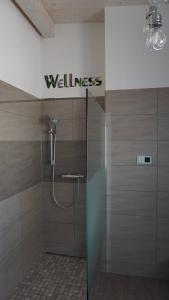 a bathroom with a shower with a wellness sign on the wall at Apartment Inge in Rheinhausen