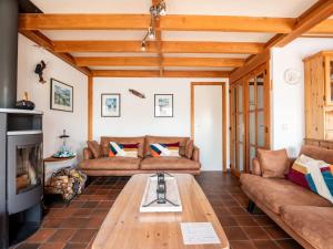 a living room with couches and a coffee table at Holiday Home Polderhuis 9 parking and shared pool by Interhome in De Haan +17 photos