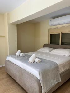a bedroom with a large bed with towels on it at Saranda View Apartments in Sarandë