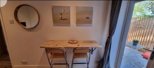 een kleine tafel met twee stoelen en een spiegel bij The Hide Away in Cromer