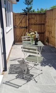 een terras met een tafel, stoelen en een hek bij The Hide Away in Cromer
