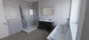 a bathroom with a tub and a sink and a bath tub at Ty Gwer proche des plages de Pors Carn & La Torche - 8 personnes in Penmarcʼh +29 photos