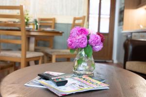 a vase of pink flowers sitting on a table at Kősüllő Vendégház in Szántód +16 photos
