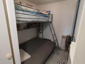 a small room with a bunk bed with a ladder at Studio carnac in Carnac