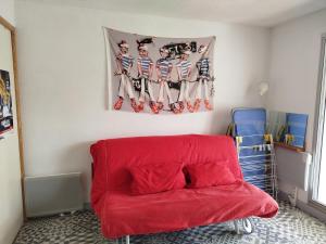 a red couch in a room with a flag at Studio carnac in Carnac