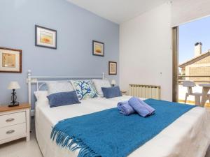 a bedroom with a large bed with a blue blanket at Holiday Home Xipres by Interhome in Torredembarra