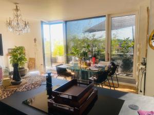 a living room with a table and a large window at Chambre appartement clo in Villejuif