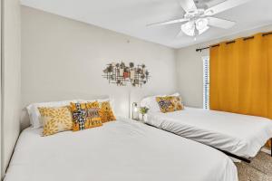 two beds in a white room with a ceiling fan at Casa Marigold ATX - Cozy Stay - Near DT & Airport in Austin +8 photos