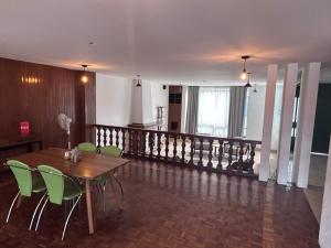 a dining room with a table and green chairs at Habitacion Berlin en The Green Door in Aguascalientes