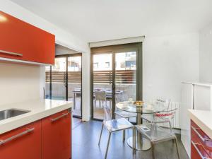 une cuisine avec des placards rouges et une table en verre dans l'établissement Apartment Costa Serena by Interhome, à Sant Antoni de Calonge