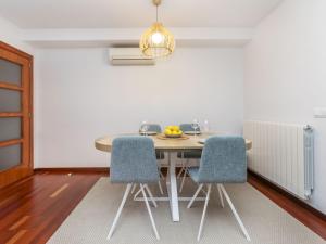 une table à manger avec des chaises bleues et un lustre dans l'établissement Apartment Costa Serena by Interhome, à Sant Antoni de Calonge