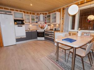 SevettijärviにあるHoliday Home Nirvana by Interhomeのテーブルと白い冷蔵庫のあるキッチン