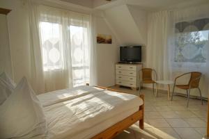 a bedroom with a bed and a tv and chairs at Ferienappartement Teresa in Sławoszynko
