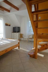 a bedroom with a bed and a tv and a staircase at Ferienappartement Teresa in Sławoszynko