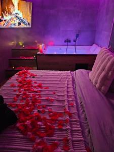 a bedroom with roses on a bed with a bath tub at Ecrin des Alpes, Jacuzzi, Netflix, Ambiance chalet in Saint-Étienne
