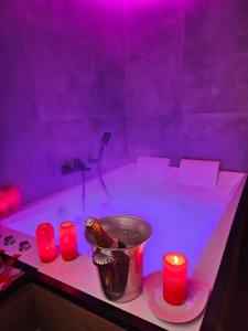 a purple bathroom with a tub with red candles at Ecrin des Alpes, Jacuzzi, Netflix, Ambiance chalet in Saint-Étienne +5 photos