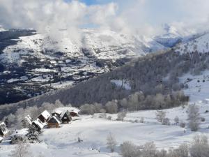 ein schneebedeckter Berg mit einem Haus im Vordergrund in der Unterkunft Appart montagne 3 étoiles Saint-Lary station in Saint-Lary-Soulan + 11 Fotos