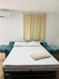 a bed in a room with a blue couch at Libertad B in Santiponce