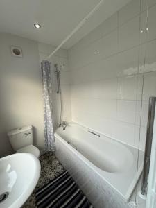 Un baño con bañera, inodoro y lavabo. en Cosy Lincoln Home Sleeps 6 with Parking, en Boultham 25 fotos más