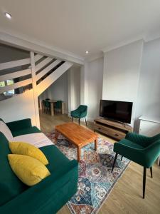 Una sala de estar con un sofá verde y un televisor. en Cosy Lincoln Home Sleeps 6 with Parking, en Boultham