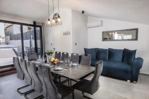 a dining room with a table and a blue couch at Poolhouse Domus in Solin