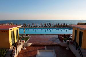 a large swimming pool with the ocean in the background at Mercure Civitavecchia Sunbay Park Hotel in Civitavecchia