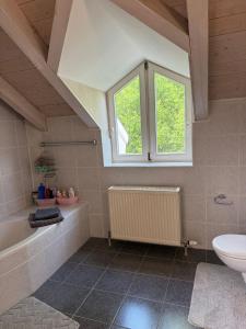 a bathroom with a tub and a toilet and a window at Natur pur! in Nieder-Olm +5 photos