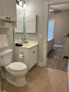 une salle de bain avec des toilettes blanches et un lavabo dans l'établissement Birdie on the Green, à Myrtle Beach