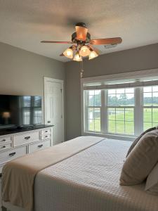 une chambre avec un lit et un ventilateur de plafond dans l'établissement Birdie on the Green, à Myrtle Beach