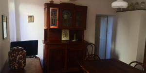 a dining room with a large wooden cabinet and a table at C'era una volta in Guardistallo
