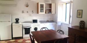 a kitchen with a table and a stove and a microwave at C'era una volta in Guardistallo