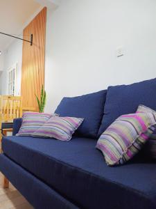 a blue couch with three pillows on it at Casa Vélez - cómoda, moderna y bien ubicada en Tres Arroyos in Tres Arroyos