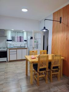 a kitchen with a wooden table and chairs at Casa Vélez - cómoda, moderna y bien ubicada en Tres Arroyos in Tres Arroyos +26 photos