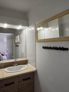 un baño con lavabo y espejo en Mazet climatisé avec piscine & tennis Résidence calme proche Lavandou, en Bormes-les-Mimosas 4 fotos más