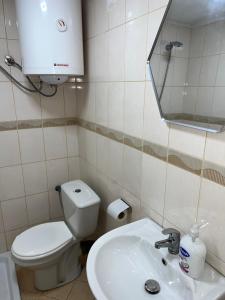 a bathroom with a toilet and a sink and a mirror at Saranda View Apartments in Sarandë