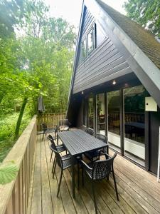 eine Holzterrasse mit einem Tisch und Stühlen darauf in der Unterkunft Chalet Het Hulstje 1 in Durbuy