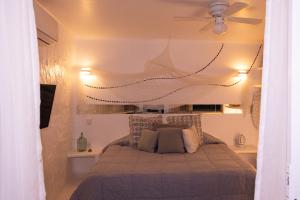 a bedroom with a bed with a ceiling fan at El Sho - Hotel orgánico in Bucerías
