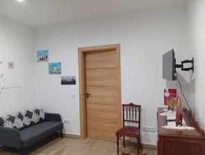 a living room with a blue couch and a wooden door at Casa Pito in Santo António do Baldio