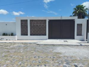 a house with a garage and a palm tree at Casa sola in Tlayecac