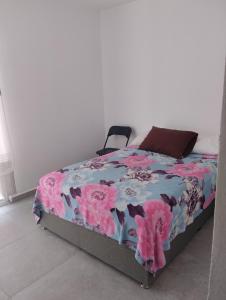 a bedroom with a bed with a floral bedspread at Casa sola in Tlayecac
