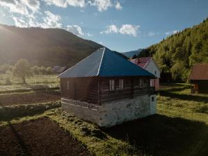 a small building with a blue roof in a field at Stara brvnara Lubnice 