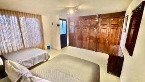 a bedroom with a bed and wooden cabinets and a window at Casa Mia Nanacamilpa Luciernagas in Nanacamilpa +40 photos